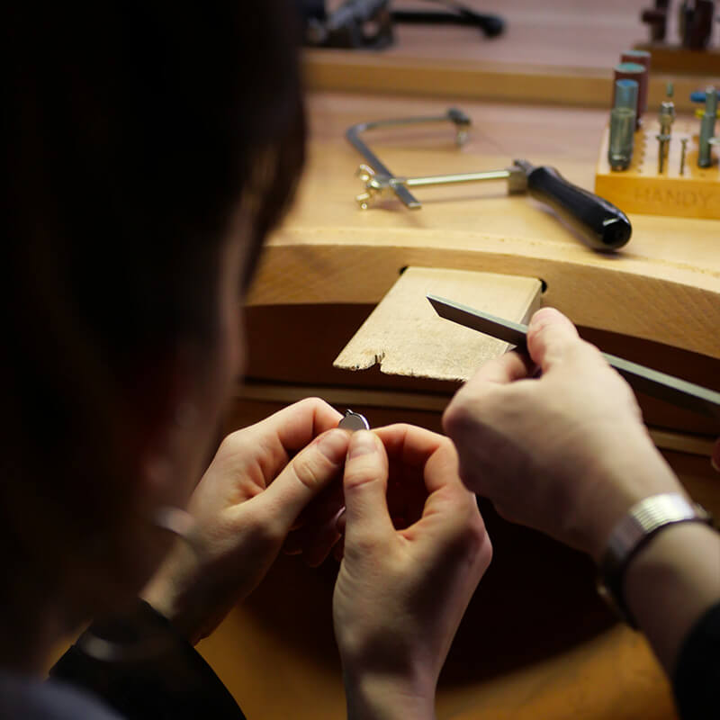 Photo des mains en train de créer son pendentif. 